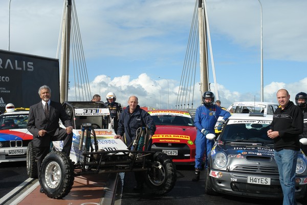 Acting Mayor Arthur Anae, Kevin Hall of Counties Manukau Off-road Racing Club and Targa Event Director Peter Martin at the launch of Full Throttle on the Ormiston Road Bridge with drivers who will take part in the event.